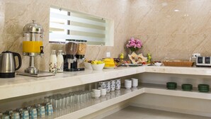 A modern kitchen with a marble backsplash, a coffee machine, and a breakfast bar. - TecnoHotel Mérida Norte (Mérida)