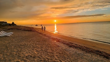 Walking along the beach, guests can enjoy the calm ocean and scenic views.