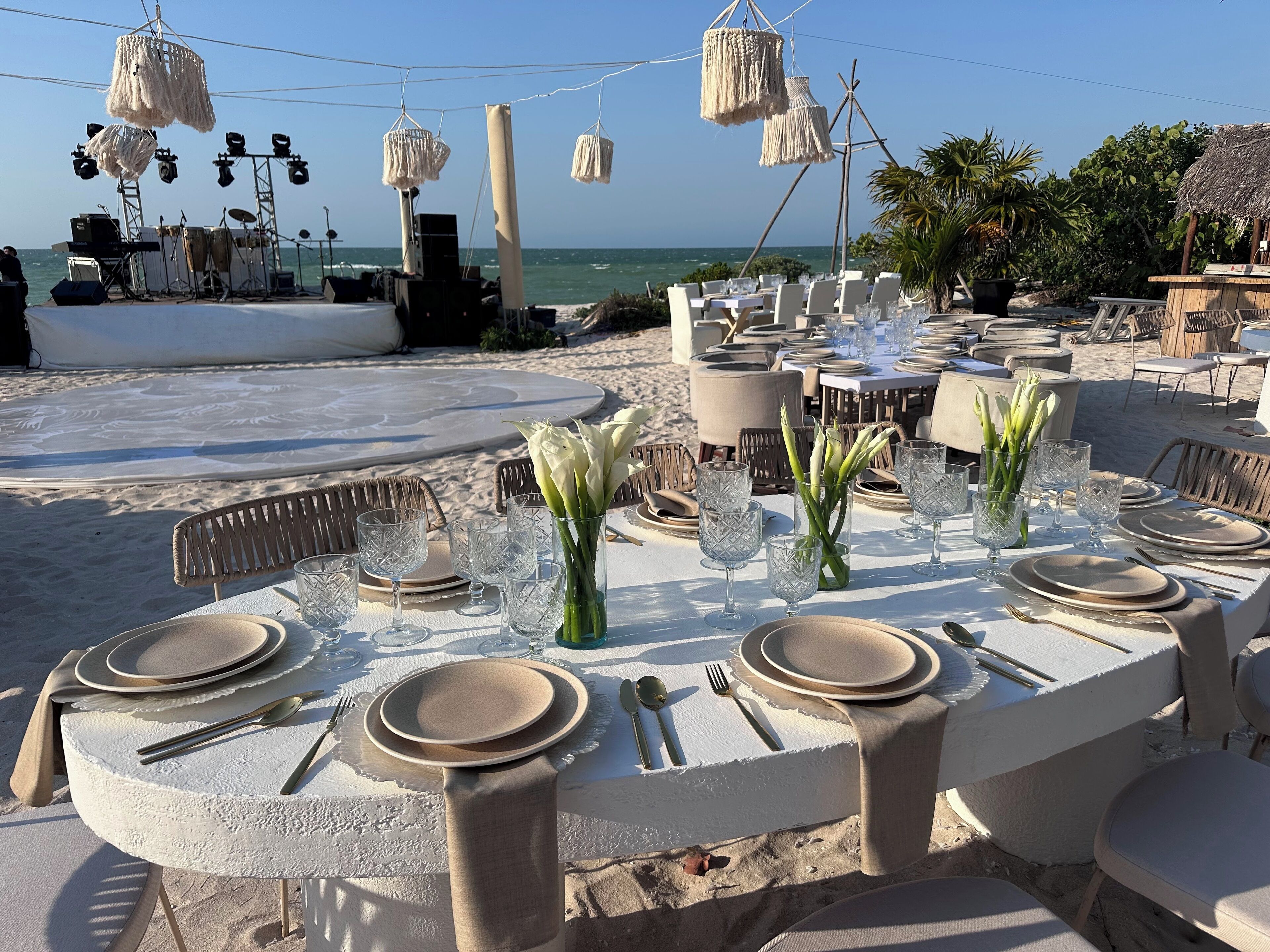 An outdoor dining area with tables set for a meal, overlooking the sea.