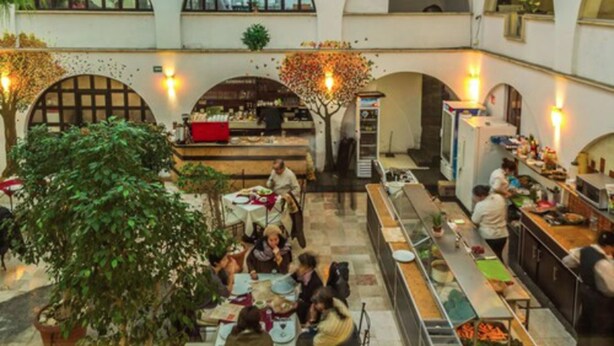 A spacious indoor dining area with multiple tables and a central bar area. - Hotel Calli Quetzalcoatl (San Pedro Cholula)