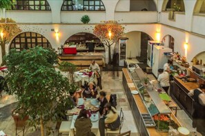 A spacious indoor dining area with multiple tables and a central bar area. - Hotel Calli Quetzalcoatl (San Pedro Cholula)