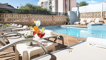 Alberca al aire libre, sombrillas en la alberca y camastros