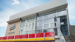 A modern building with large windows and a sign that reads "D'River Guest House." - D'River Guesthouse (Bandung)