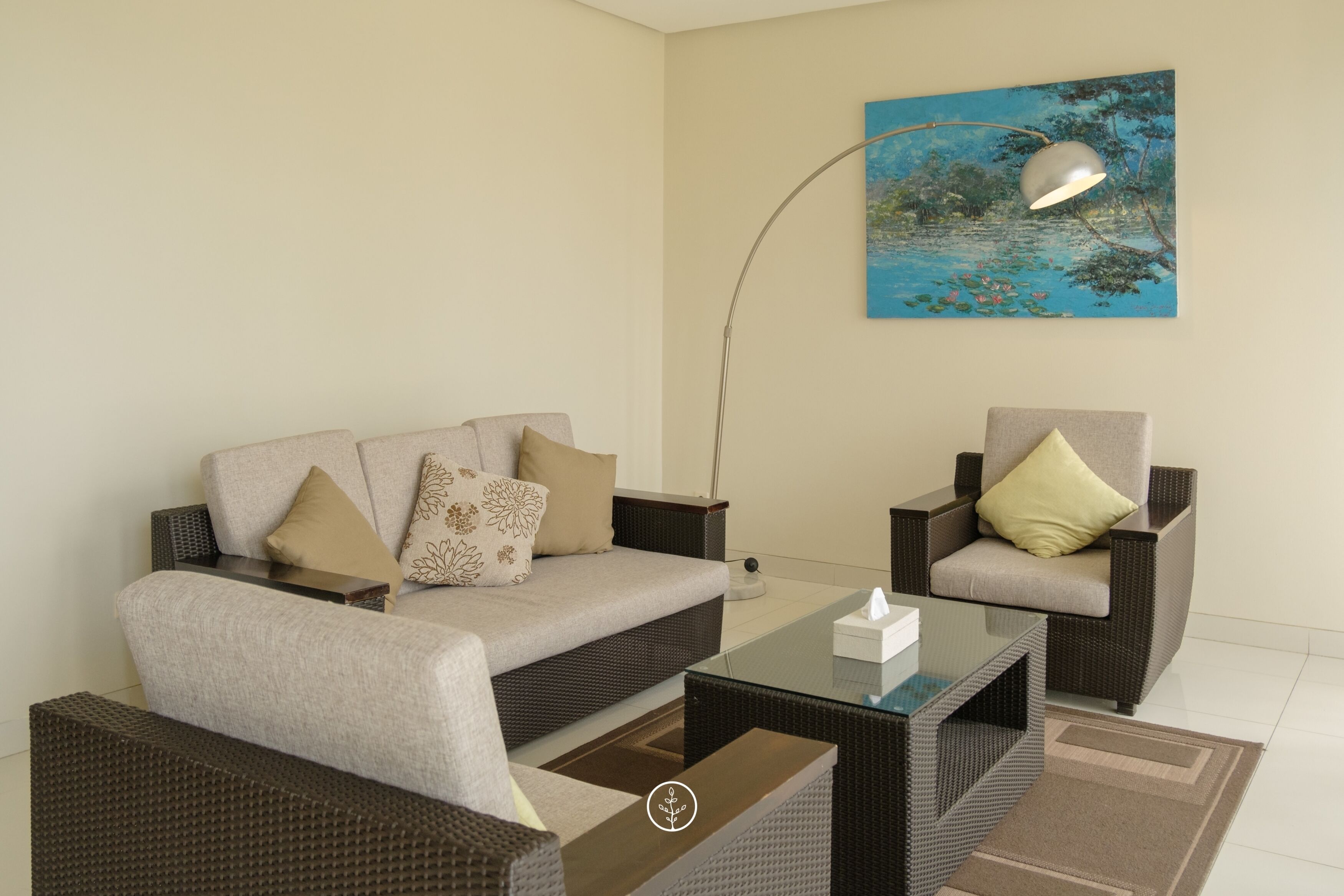Una sala de estar moderna con un sofá, sillones, una mesa de centro y un cuadro en la pared.