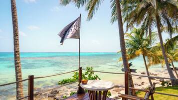 Enjoy a tranquil beachside retreat with a deck, round table, and two chairs overlooking the ocean.