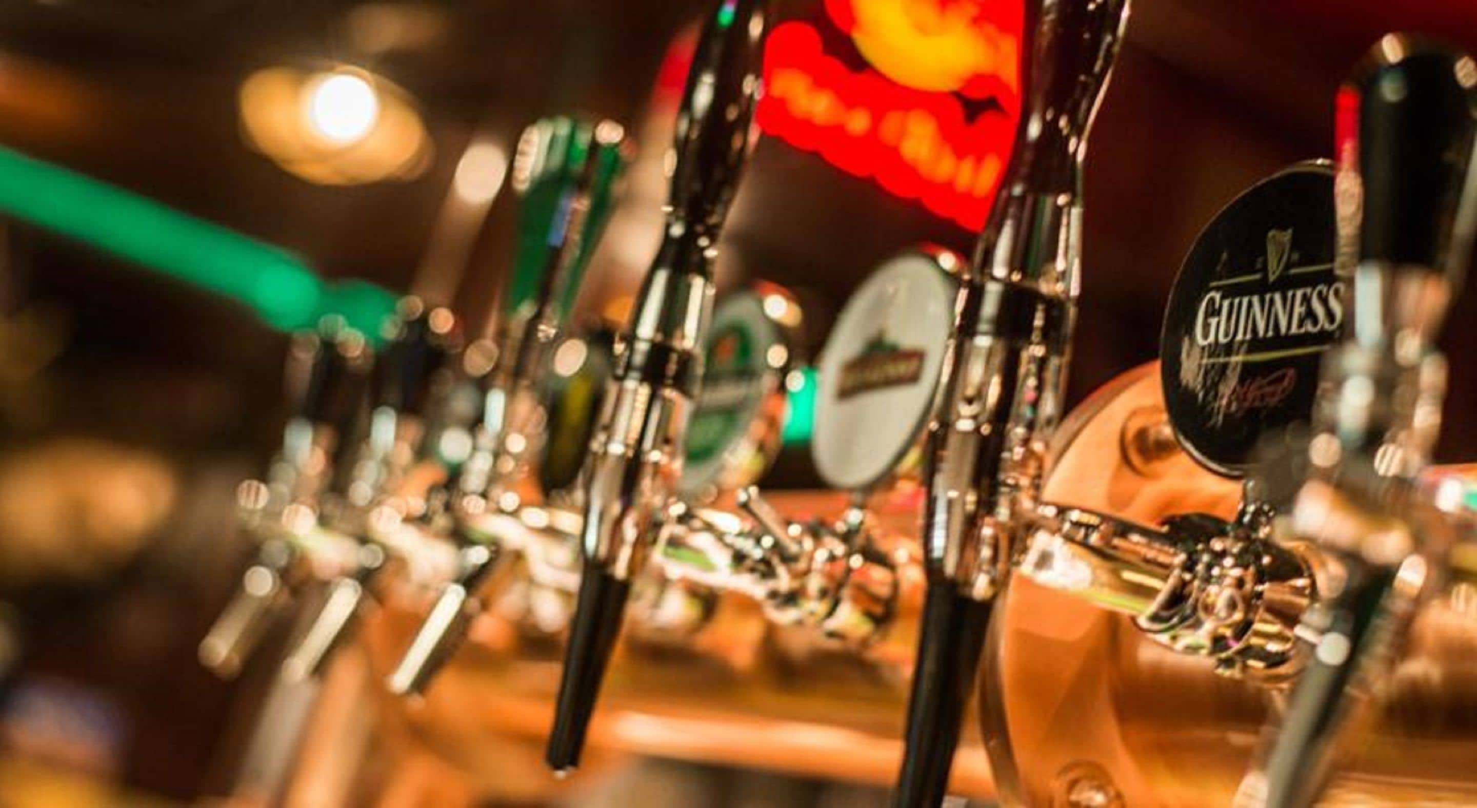 Una fila de grifos de cerveza, con un grifo de Guinness destacándose.
