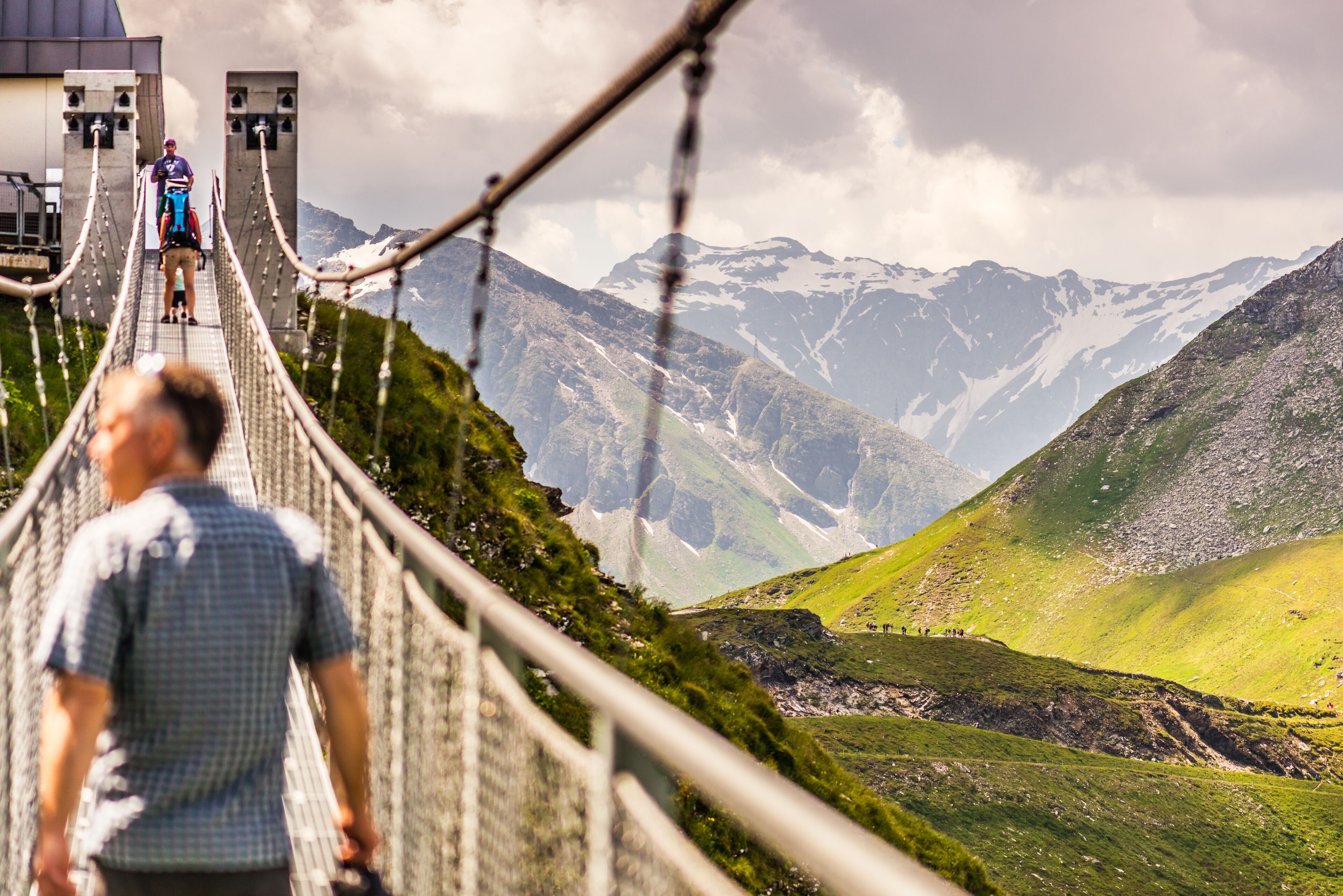 A suspension bridge with a mountainous landscape in the background.
