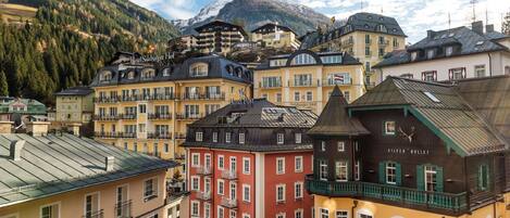 A cluster of colorful buildings with balconies, a mountain in the background, and a clear sky.