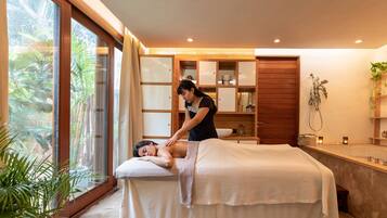 Experience a tranquil massage in a serene spa setting with a soothing view of lush greenery.
