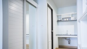 A modern kitchen with white cabinetry, a built-in sink, and a countertop. - Vanilla Residence Chiangmai (Chiang Mai)