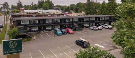 A Wildwood Inn with a parking lot, multiple vehicles, and a sign indicating the name and address.