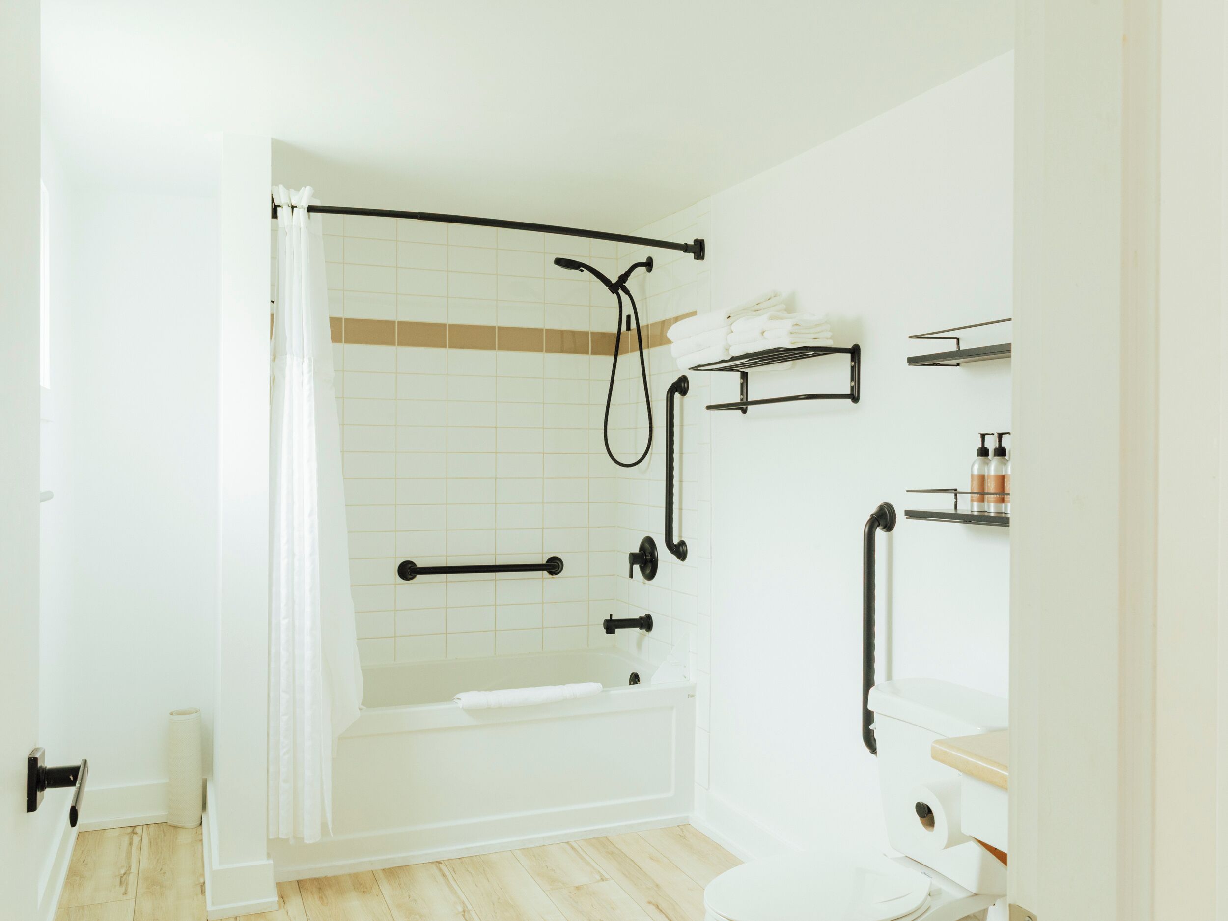 Un baño moderno con bañera, inodoro y zona de ducha.