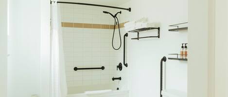 Un baño moderno con bañera, inodoro y zona de ducha.