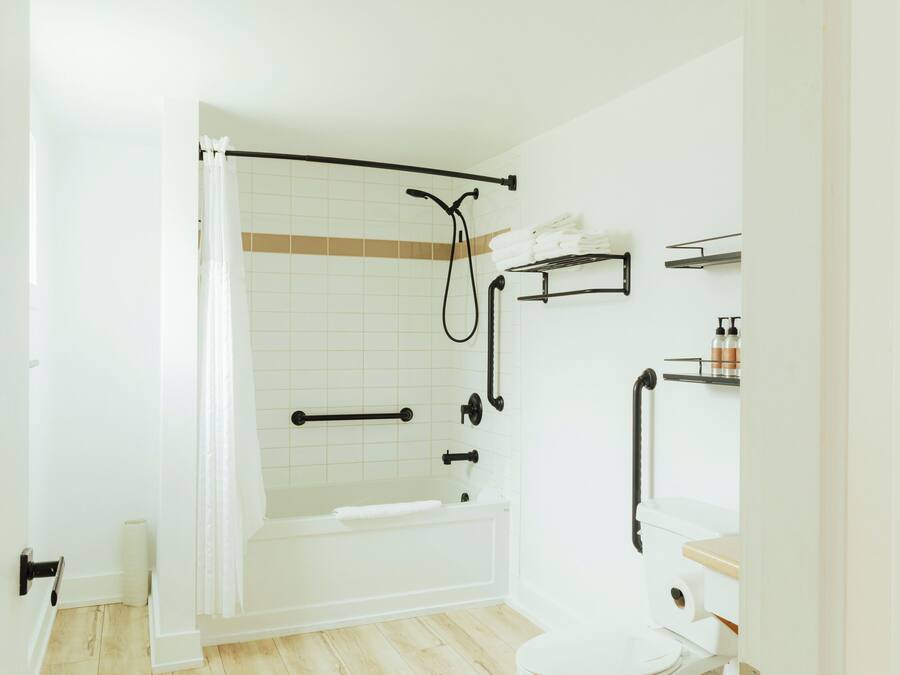 A modern bathroom with a bathtub, toilet, and shower area.