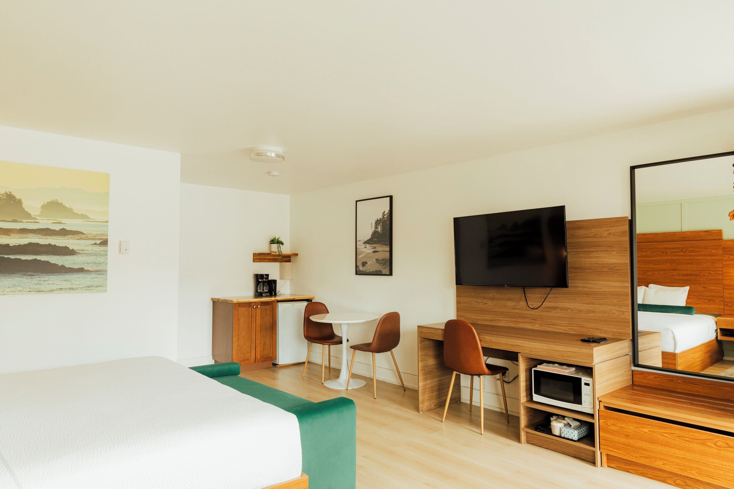 Een moderne hotelkamer met een bed, een bureau, een televisie en een zithoek.