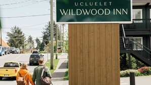 A sign for Ucluelet Wildwood Inn with a simple logo and name.