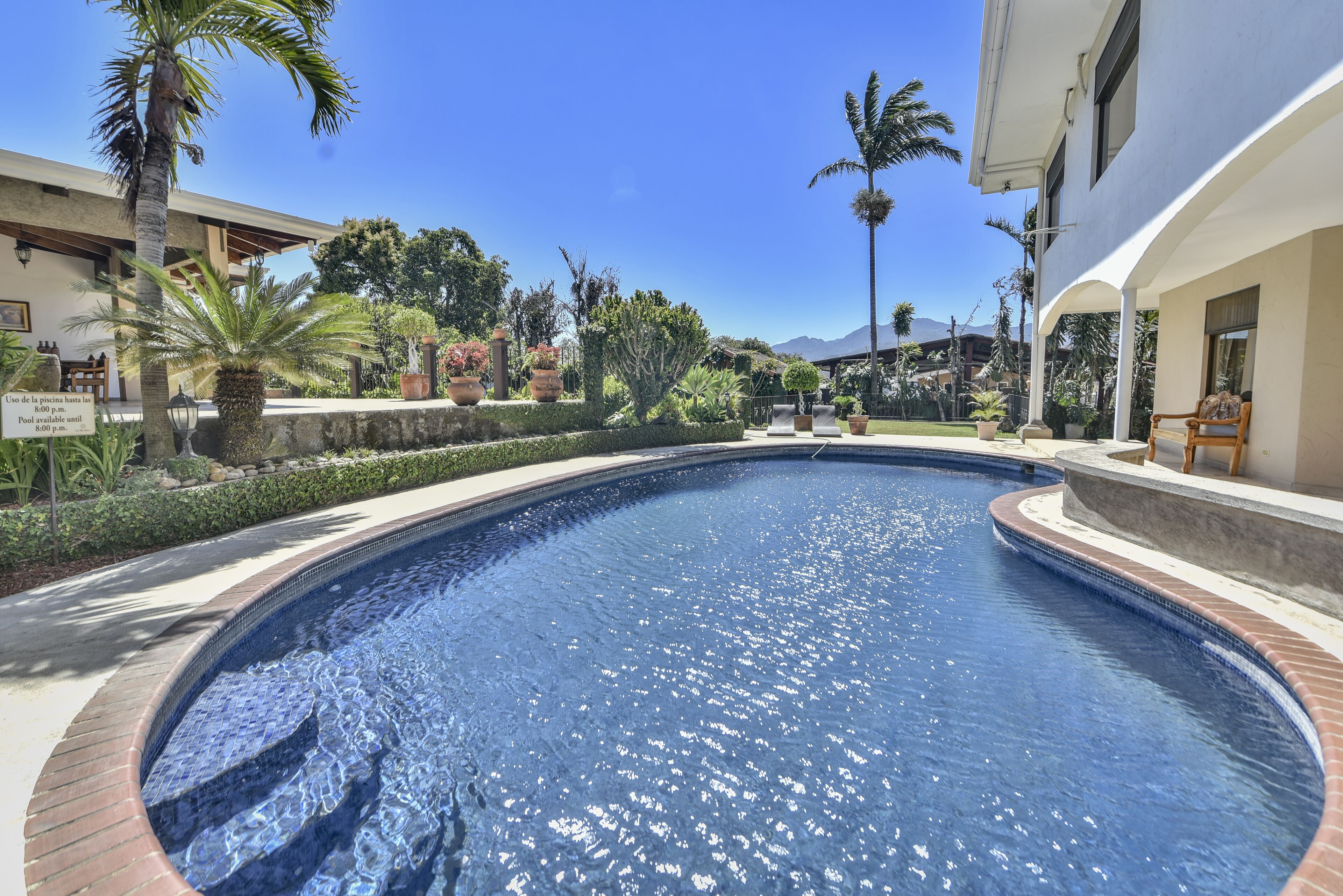 Una piscina al aire libre, tumbonas