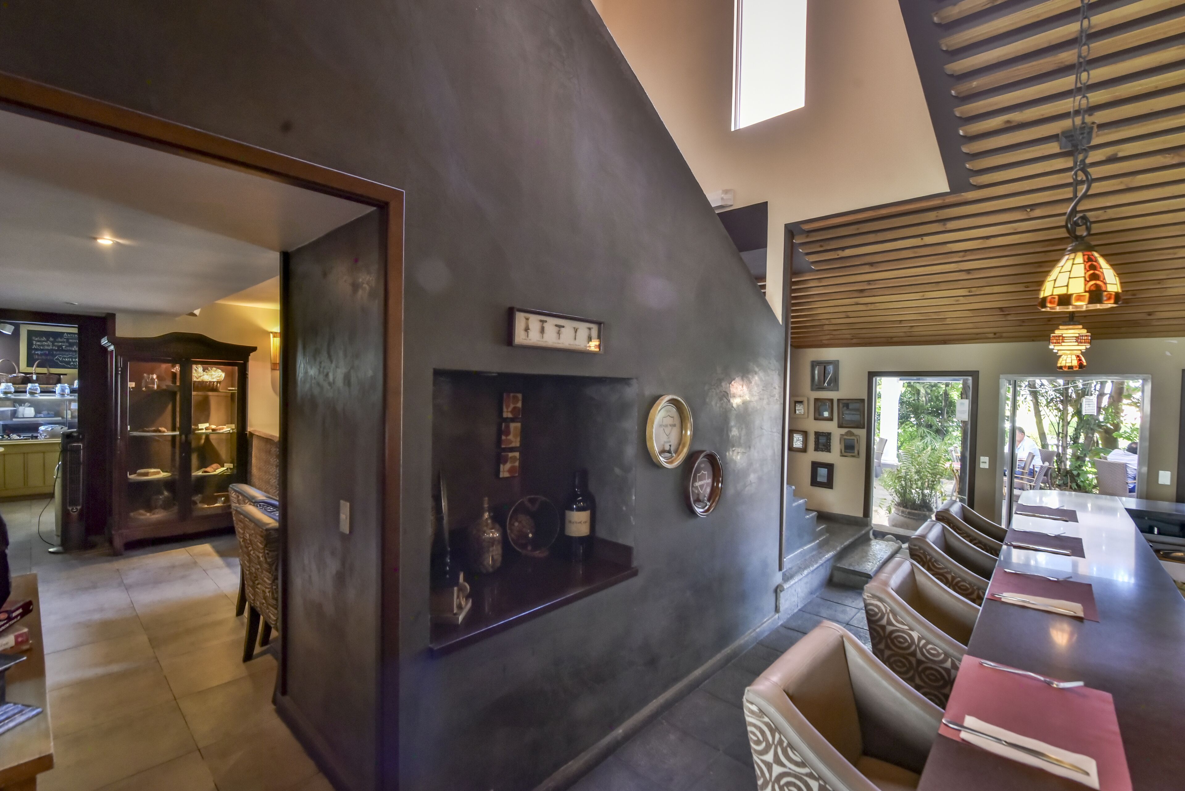 A modern interior with a bar area, seating, and a kitchen visible in the background.