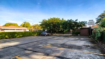 A parking lot with marked spaces, a car, and a hotel sign in the background.