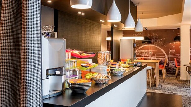 Une cuisine moderne équipée d’un buffet, comprenant un réfrigérateur, une machine à café et divers produits alimentaires.