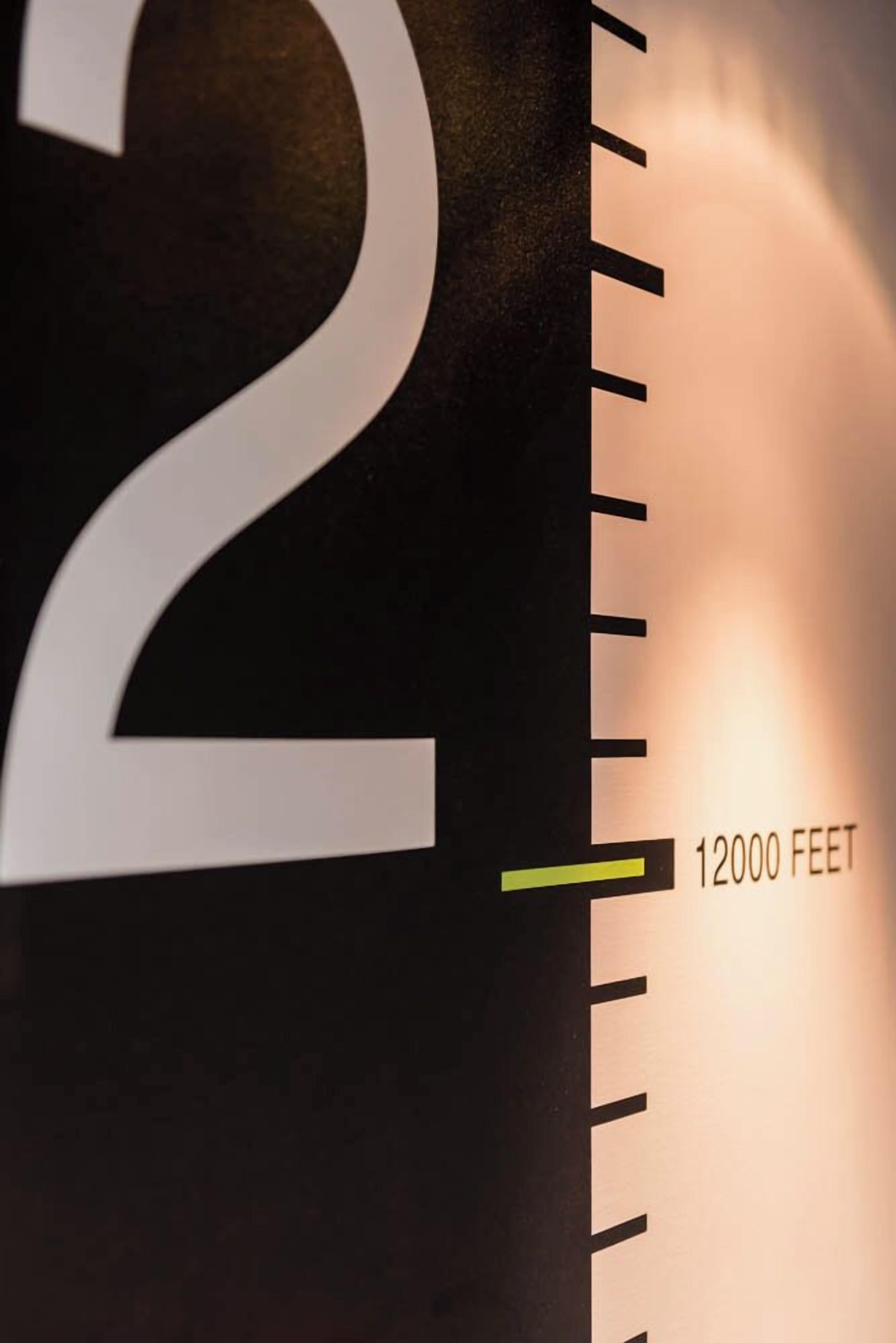 A close-up of a large number '2' and a scale marked '12000 feet' on a wall.