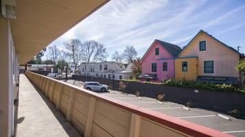 A parking lot with a row of colorful houses in the background.