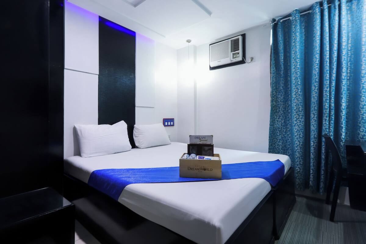 Ein Hotelzimmer mit einem Bett, einem Nachttisch, einem Schreibtisch und einem Stuhl.