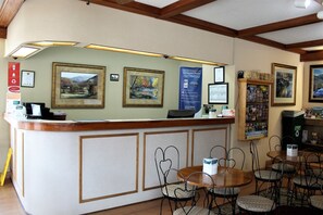 Reception area with a central desk, framed artwork, and comfortable seating.