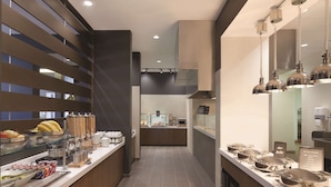 Una cocina moderna con una encimera larga, vitrinas de cristal y diversos alimentos.