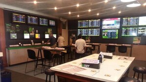 A betting shop with multiple screens displaying odds and a counter area. - Grand Tasman Hotel (Port Lincoln)