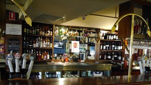 A bar with multiple liquor bottles, a beer tap area, and a Boston Bay Wines sign. - Grand Tasman Hotel (Port Lincoln)