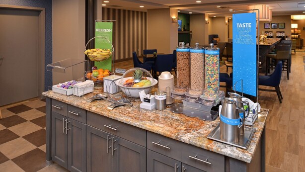 A breakfast bar with various food items and a beverage station. - Hampton Inn Broussard-Lafayette Area (Broussard)