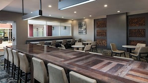 Une salle de conférence avec une longue table, de nombreuses chaises et un sol recouvert de moquette.