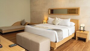 Een hotelkamer met een bed, een slaapbank, een bankje, een nachtkastje en een bijzettafeltje.
