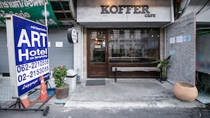 A hotel entrance with a sign for 'Koffer Cafe' and a nearby 'Art Hotel' sign. - OYO 568 Art Hotel Hua Lamphong - Hostel (Bangkok)