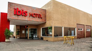 A hotel named 'ibis HOTEL' with a brick facade, large windows, and a paved entrance area. - ibis Bacabal (Bacabal)
