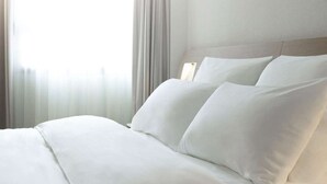 A hotel room with a neatly made bed, a headboard, and a window with curtains. - ibis Bacabal (Bacabal)