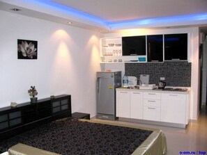 A modern kitchen with white cabinets, a refrigerator, and a microwave. - Wongamat Privacy by Good Luck Apartments (Pattaya)