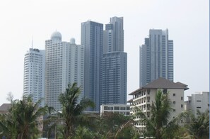 A high-rise building complex with multiple skyscrapers, surrounded by palm trees and other greenery. - Wongamat Privacy by Good Luck Apartments (Pattaya)