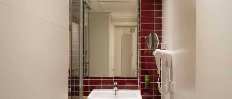 A bathroom with a white sink, a mirror, and a towel on the counter.