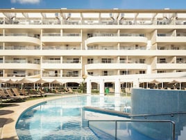 Una piscina al aire libre de temporada, sombrillas