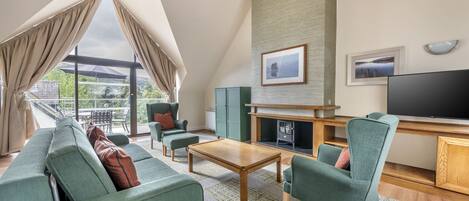 A modern living room with a sofa set, a coffee table, a fireplace, and a television.