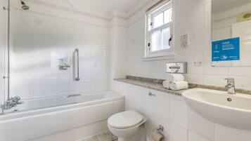 A modern bathroom with a bathtub, toilet, and sink.