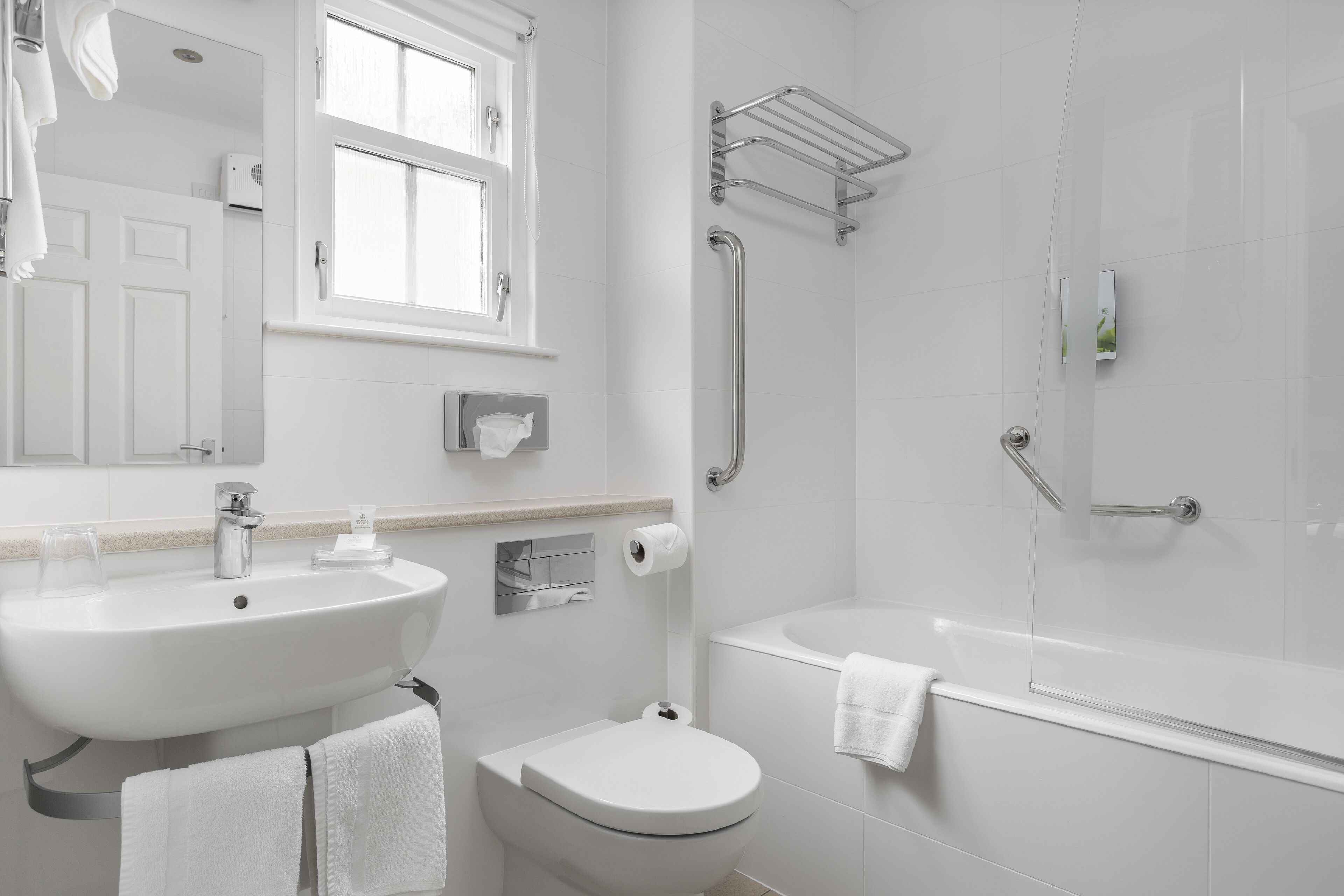 A modern bathroom with a sink, toilet, and bathtub.