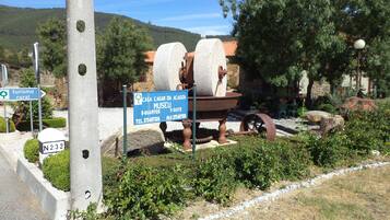 A rural tourism sign with a large stone structure, a telephone booth, and a stone path.