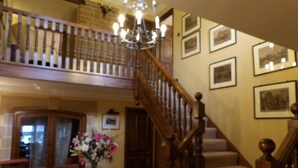 A staircase with wooden railings and a chandelier. - Broccoli Bottom (Oakham)