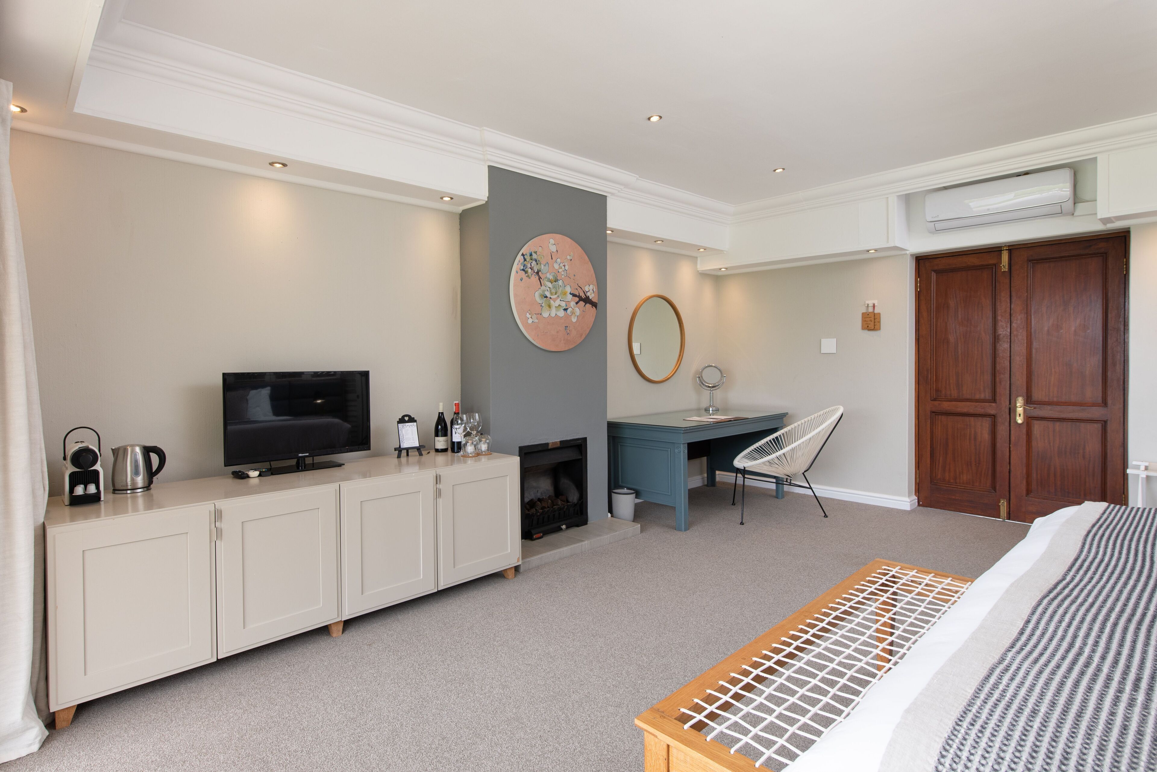 Une chambre à coucher comprenant un lit, une télévision, un bureau, une chaise, une cheminée et une armoire.