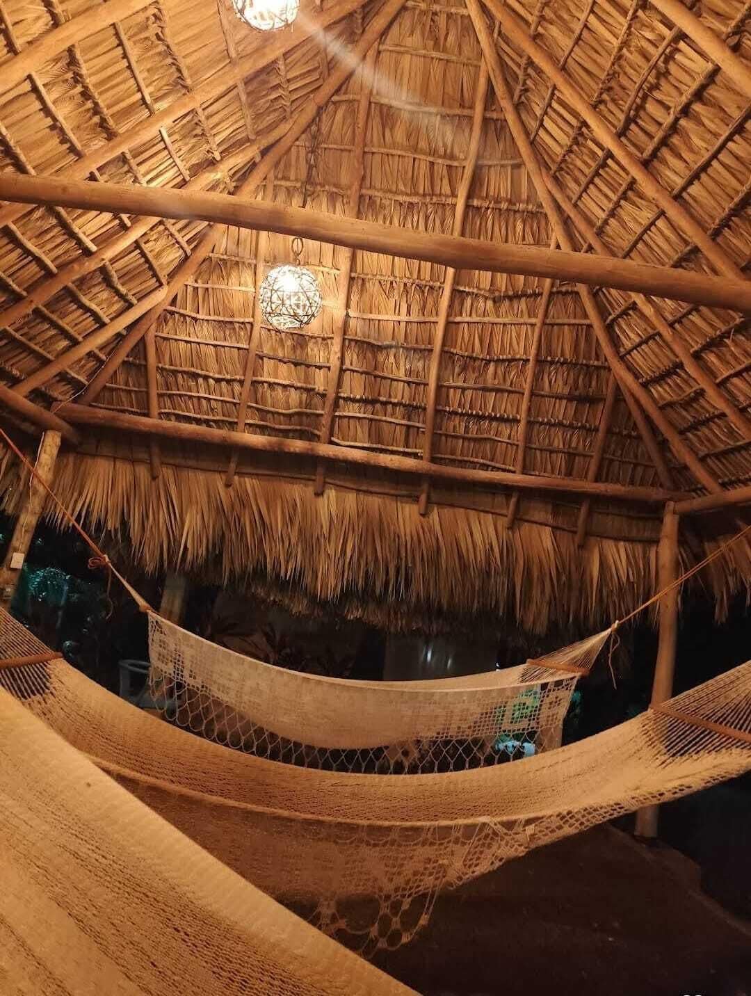 A thatched-roof structure with a hammock.
