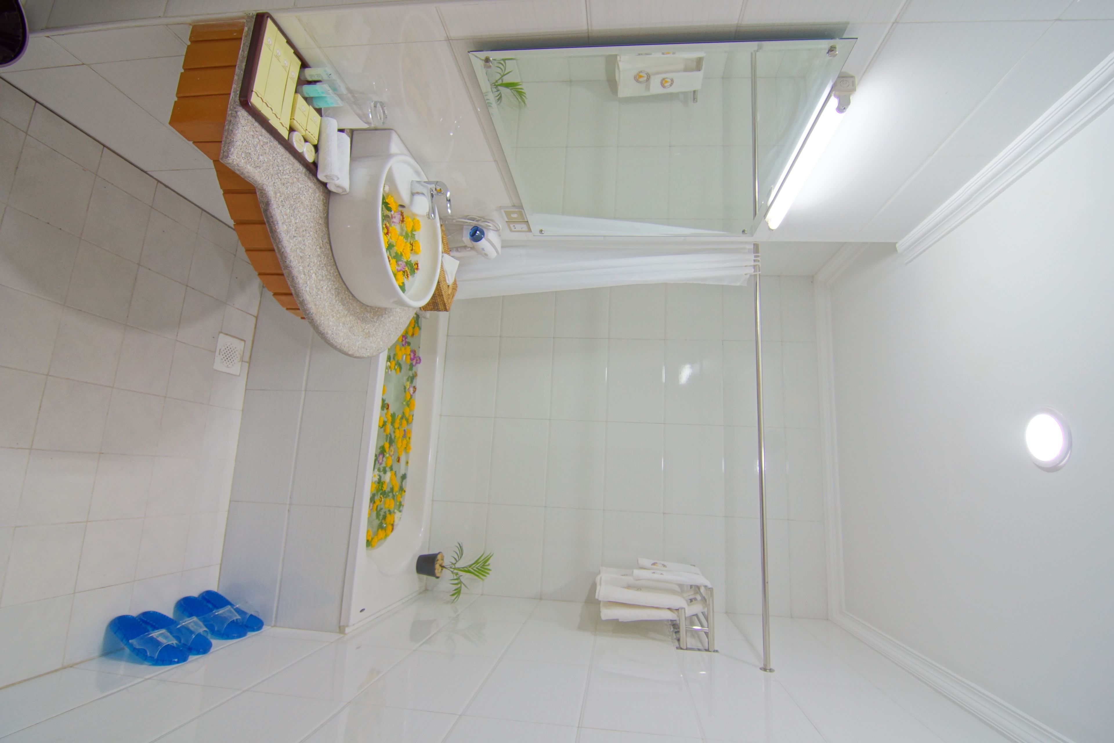 Un bagno con doccia, lavandino e specchio. Asciugamani e articoli da toilette presenti sul ripiano.