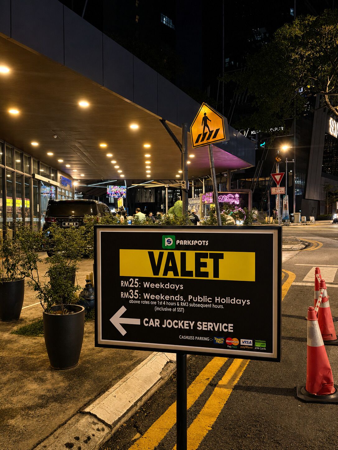 A parking sign for Valet Car Service with pricing details and payment options.